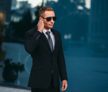 Male bodyguard uses security earpiece outdoors
